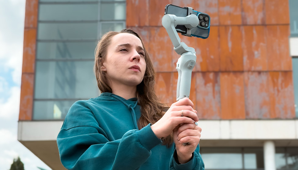 Notre ADN : producteur et éditeur de médias Jeune femme filmant avec son smartphone